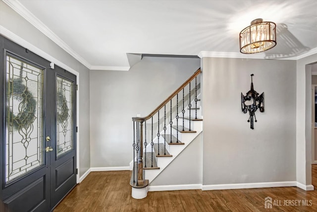 entrance foyer featuring ornamental molding, an inviting chandelier, and hardwood / wood-style floors