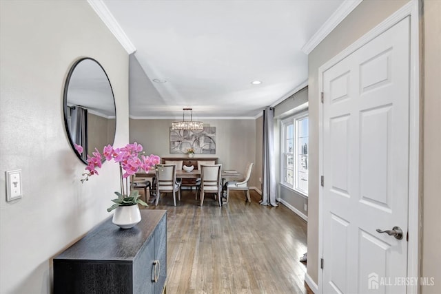 entrance foyer with a chandelier, ornamental molding, and wood-type flooring