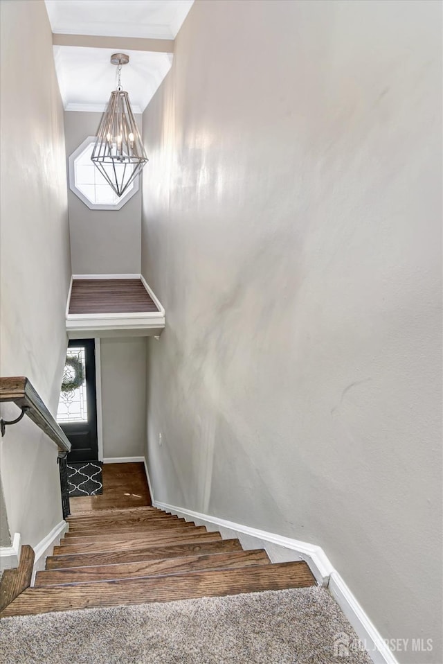 stairway featuring hardwood / wood-style floors and a chandelier