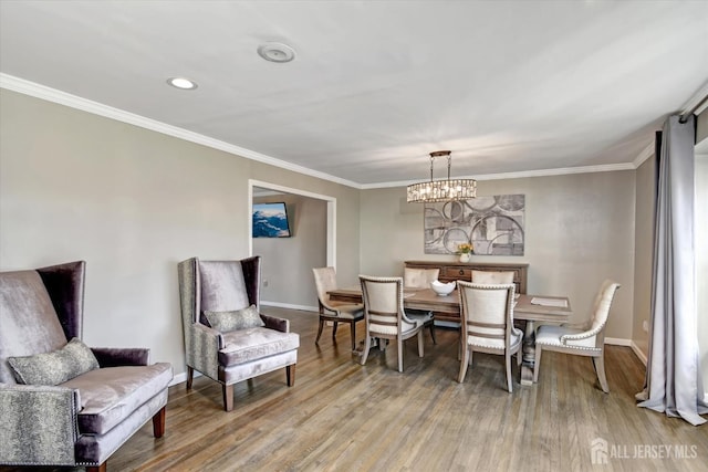 dining area featuring a notable chandelier, hardwood / wood-style floors, and crown molding