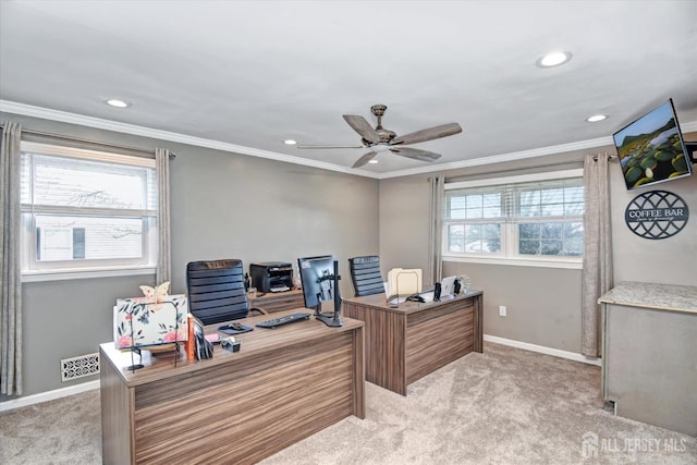 carpeted home office with ceiling fan, a wealth of natural light, and crown molding