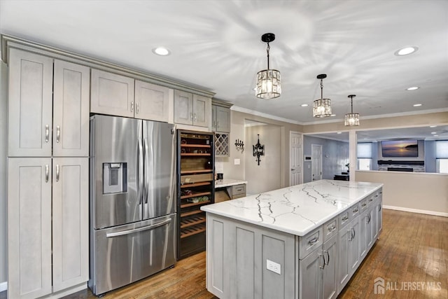 kitchen featuring a kitchen island, gray cabinets, pendant lighting, and stainless steel fridge with ice dispenser