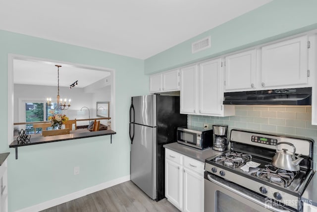 806 Darlington Dr, Old Bridge, NJ 08857 - kitchen with stainless steel appliances, under cabinet range hood, dark countertops, tasteful backsplash, and white cabinets