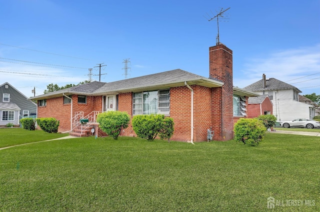 77 Manhattan Ave, Avenel, NJ 07001 - view of front of property with a chimney, a front yard, brick siding, and a shingled roof