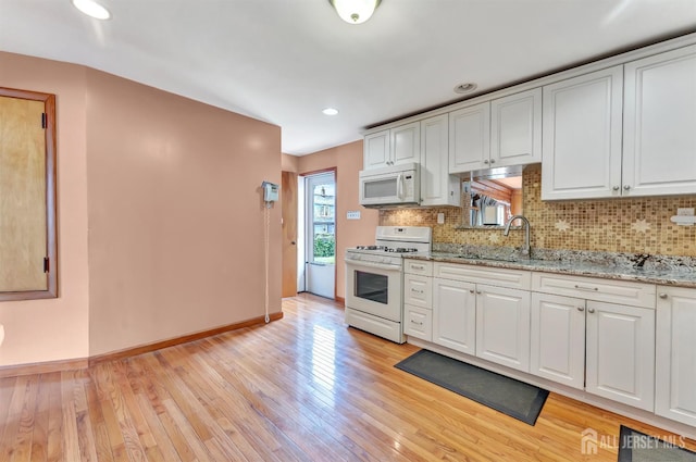 77 Manhattan Ave, Avenel, NJ 07001 - kitchen featuring white appliances, light wood-style flooring, backsplash, white cabinets, and recessed lighting