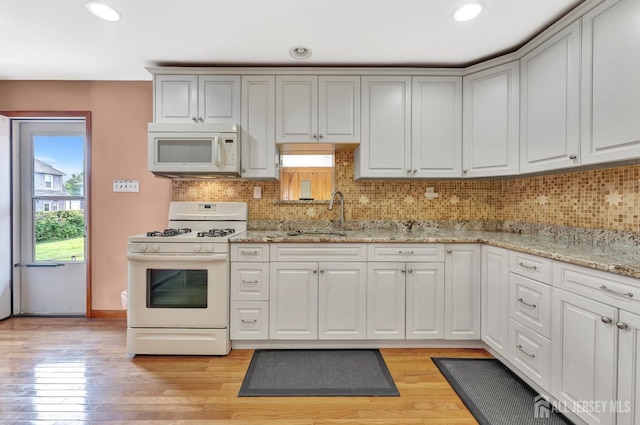 77 Manhattan Ave, Avenel, NJ 07001 - kitchen with white appliances, tasteful backsplash, light wood-style flooring, recessed lighting, and light stone countertops
