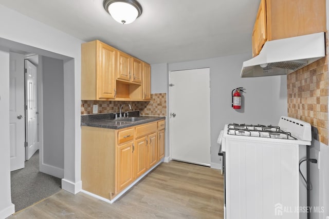 kitchen with light hardwood / wood-style floors, decorative backsplash, sink, white range with gas stovetop, and light brown cabinets