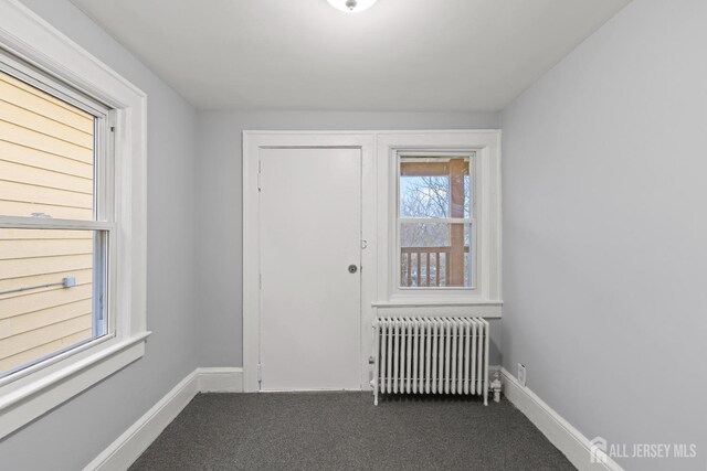 interior space with radiator and dark colored carpet