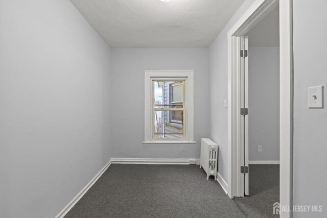 carpeted empty room with radiator