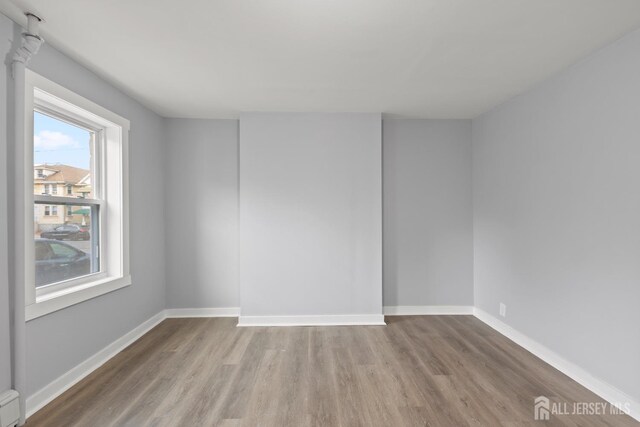 spare room with light hardwood / wood-style floors and a baseboard radiator