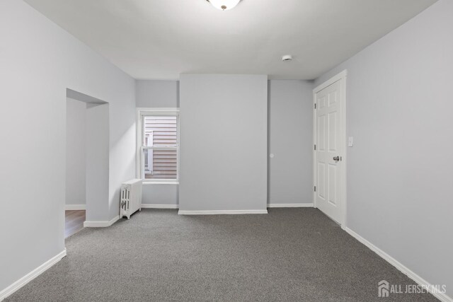 carpeted empty room with radiator