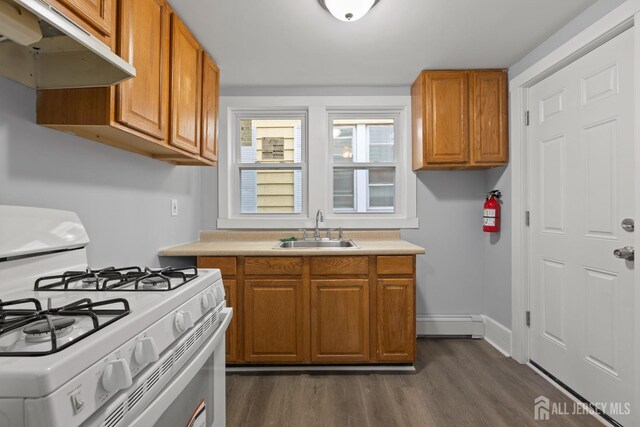 kitchen featuring dark hardwood / wood-style flooring, sink, white gas range oven, and a baseboard radiator