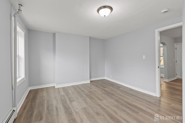 spare room with light wood-type flooring and baseboard heating