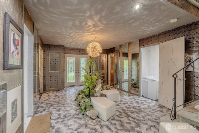 bathroom with separate washer and dryer, a textured ceiling, french doors, and a chandelier