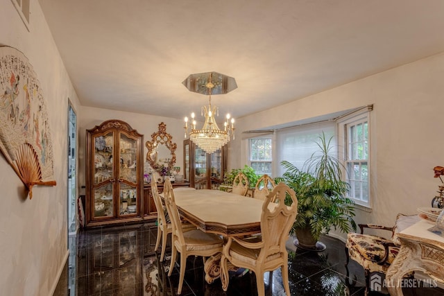dining area with granite floors, a chandelier, and baseboards