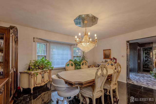 dining area featuring a chandelier and dark tile patterned flooring