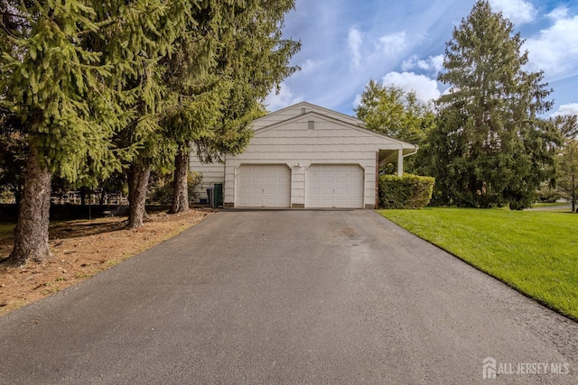 view of front of home featuring driveway, a front lawn, and an attached garage