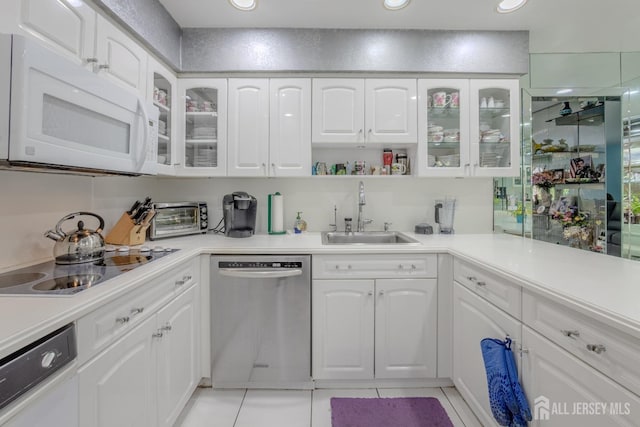 kitchen featuring dishwasher, white microwave, a sink, electric cooktop, and light tile patterned floors