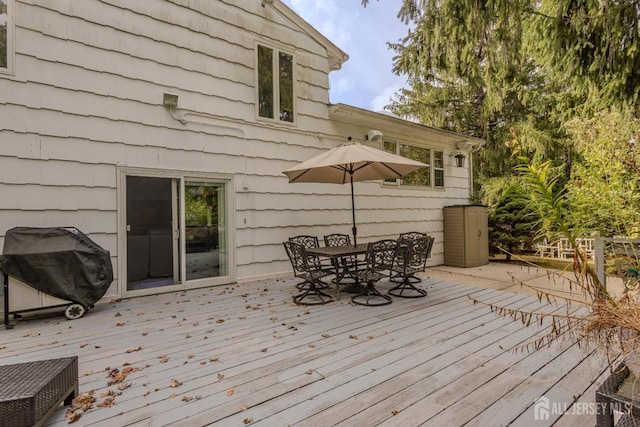 wooden terrace with grilling area and outdoor dining space
