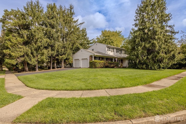 view of front of house with a front yard, asphalt driveway, and an attached garage