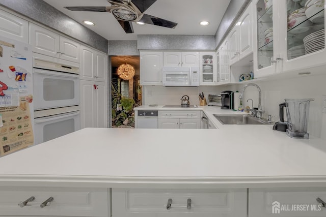 kitchen featuring white appliances, a sink, glass insert cabinets, ceiling fan, and a peninsula
