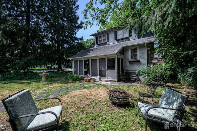 570 Main St, Metuchen, NJ 08840 - rear view of house featuring a sunroom, an outdoor fire pit, a lawn, and roof with shingles