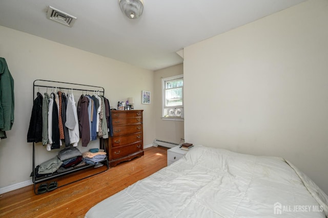 570 Main St, Metuchen, NJ 08840 - bedroom featuring wood finished floors and a baseboard radiator