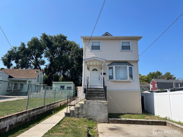 view of front of property featuring fence private yard and an outdoor structure