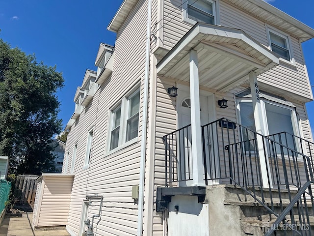 view of side of home featuring fence