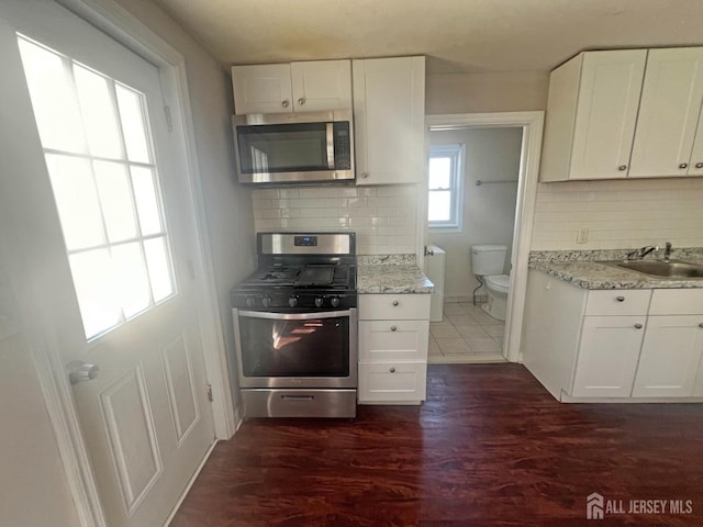 865 Kreil St, Perth Amboy, NJ 08861 - kitchen featuring appliances with stainless steel finishes, a sink, white cabinets, and tasteful backsplash