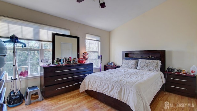 bedroom featuring light hardwood / wood-style flooring, vaulted ceiling, and ceiling fan