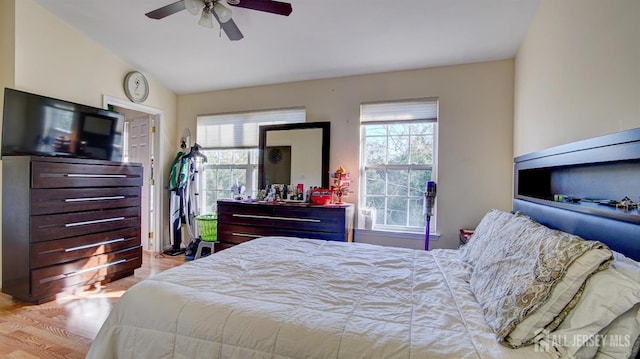 bedroom featuring lofted ceiling, ceiling fan, and light hardwood / wood-style flooring