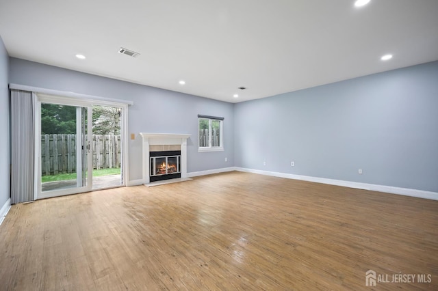 70 Lexington Cir, Old Bridge, NJ 07747 - unfurnished living room featuring a glass covered fireplace, light wood-style flooring, and recessed lighting