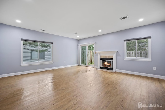 70 Lexington Cir, Old Bridge, NJ 07747 - unfurnished living room featuring a glass covered fireplace, wood finished floors, and recessed lighting