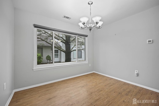 70 Lexington Cir, Old Bridge, NJ 07747 - unfurnished room with a chandelier and wood finished floors
