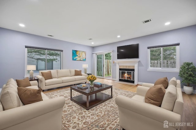 70 Lexington Cir, Old Bridge, NJ 07747 - living area featuring plenty of natural light, light wood-style floors, a glass covered fireplace, and recessed lighting