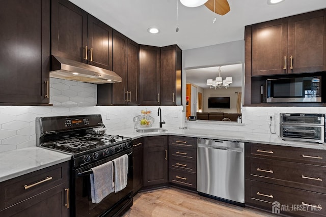 kitchen with sink, dark brown cabinets, appliances with stainless steel finishes, light stone countertops, and light hardwood / wood-style floors