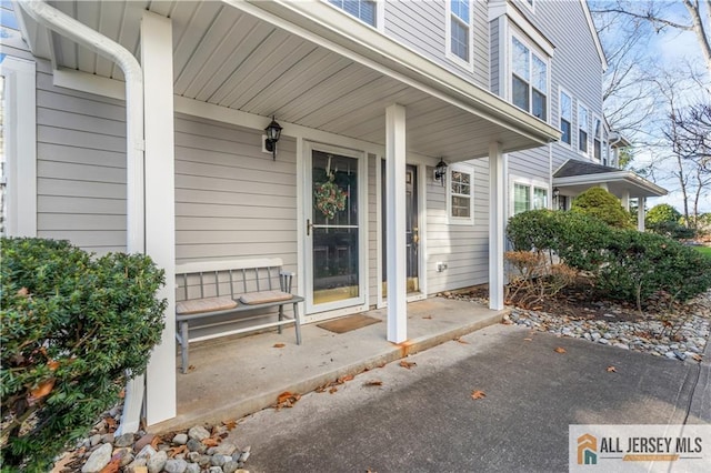 view of exterior entry featuring covered porch