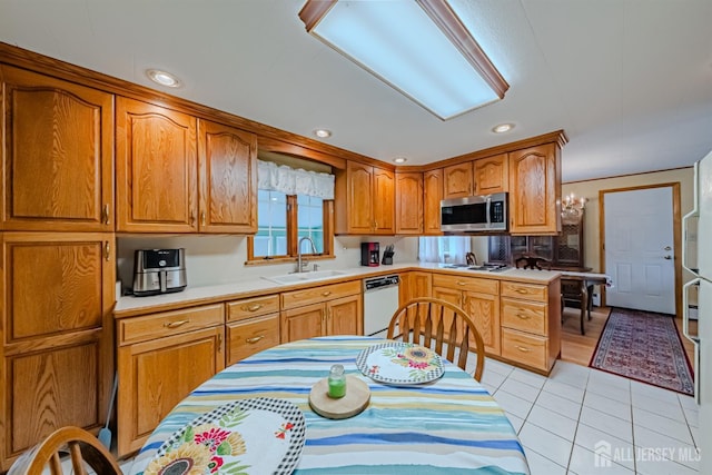 kitchen featuring light tile patterned floors, sink, and white appliances