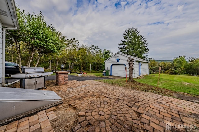 view of patio with a garage, a grill, and an outbuilding