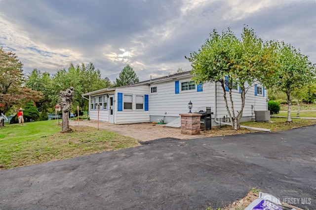 manufactured / mobile home with central air condition unit and a front yard