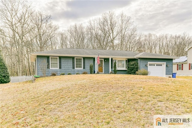 ranch-style home featuring a garage, a front yard, and fence