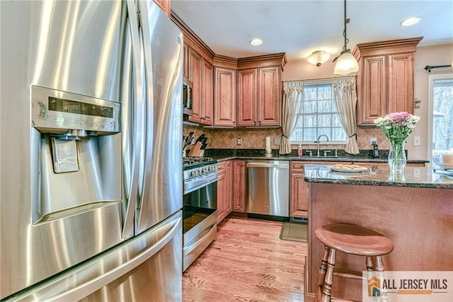 kitchen featuring a sink, plenty of natural light, appliances with stainless steel finishes, and light wood finished floors