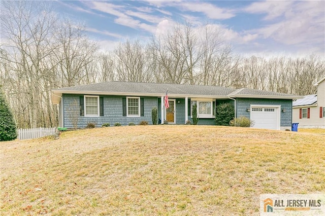 ranch-style house with a front yard, fence, and a garage