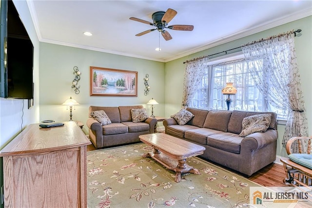 living area featuring wood finished floors, ceiling fan, and ornamental molding