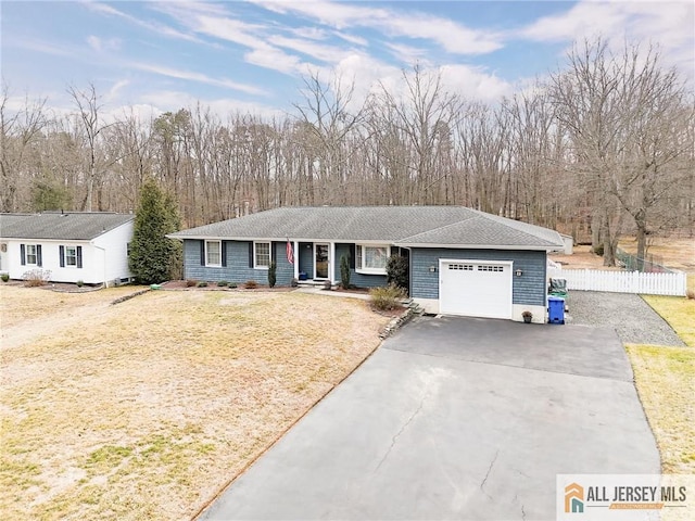 ranch-style home featuring a front yard, fence, a garage, and driveway