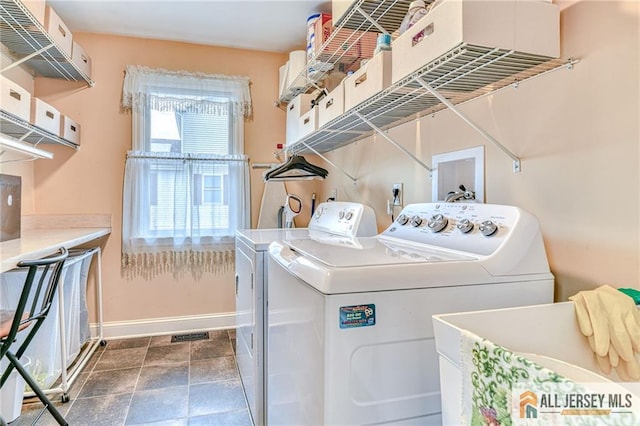 laundry area with laundry area, washer and dryer, and baseboards