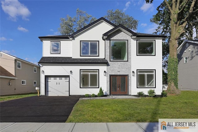 front of property with a garage, a front lawn, and french doors