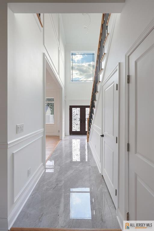 entryway with a towering ceiling and french doors