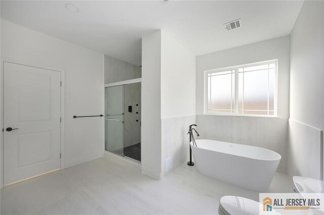 bathroom featuring toilet and separate shower and tub